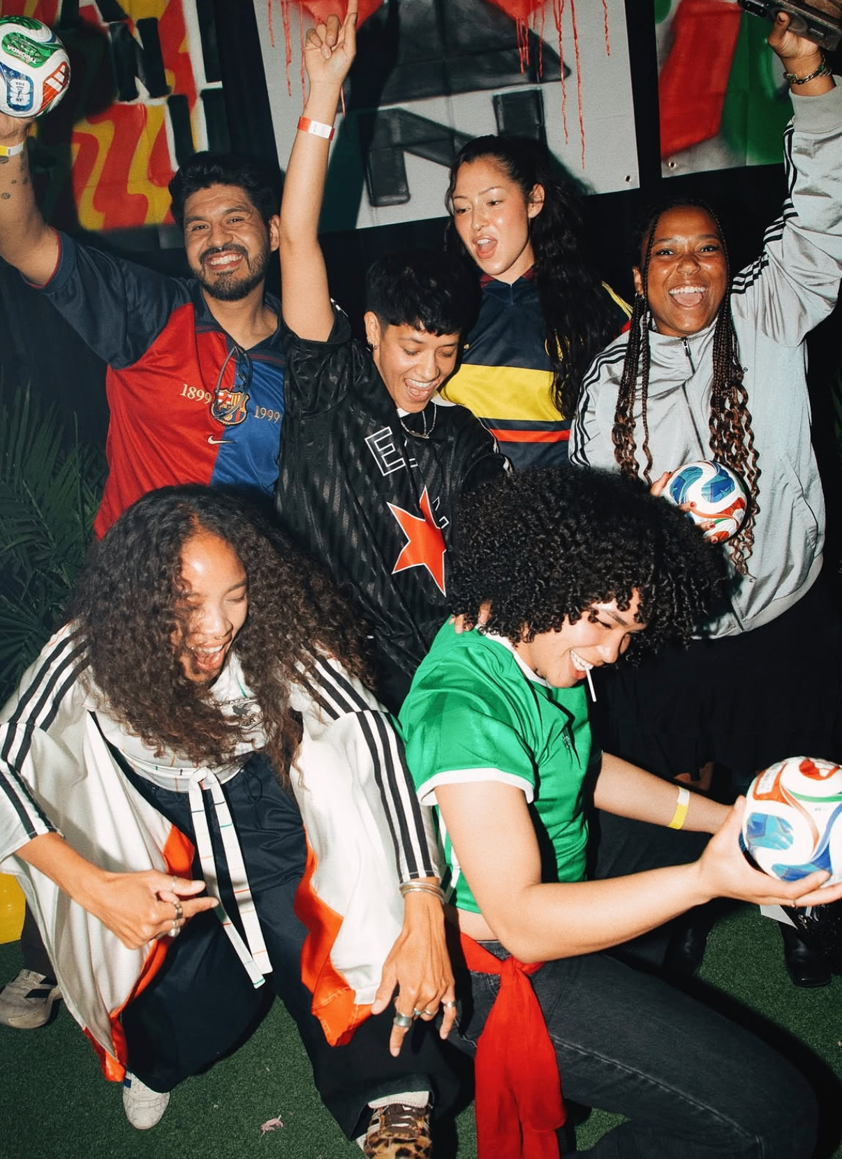Crew of friends in fútbol jerseys celebrating together